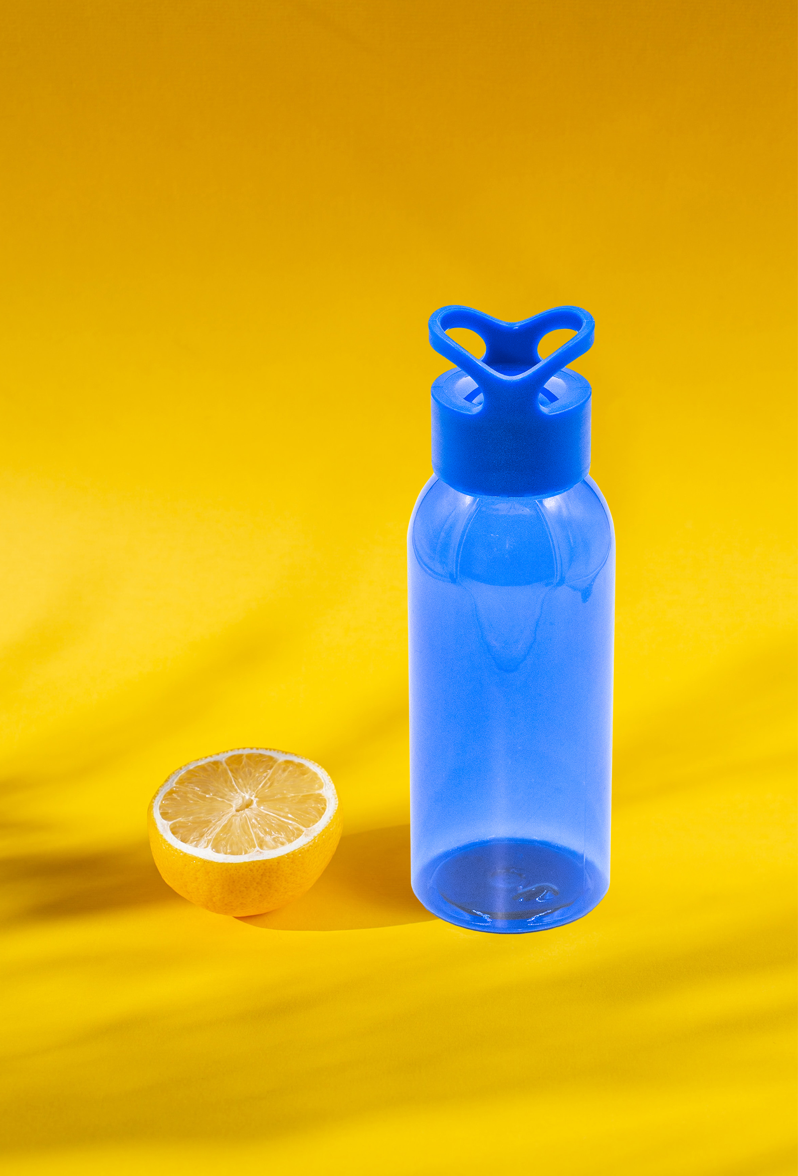 The before image of blue water bottle on a yellow background.